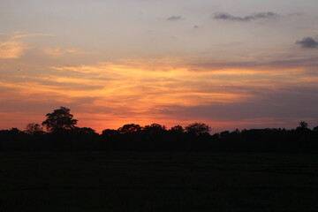Sunset Sky Clouds in the evening with Red, Orange, Yellow and purple sunlight on Golden hour after sundown, Romantic sky in summer on Dusk Twilight