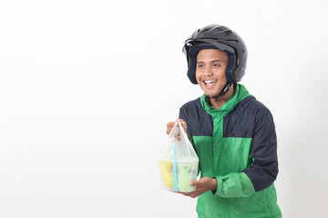 Portrait of Asian online taxi driver wearing green jacket and helmet delivering the beverages in plastic cup to customer. Isolated image on white background - Powered by Adobe