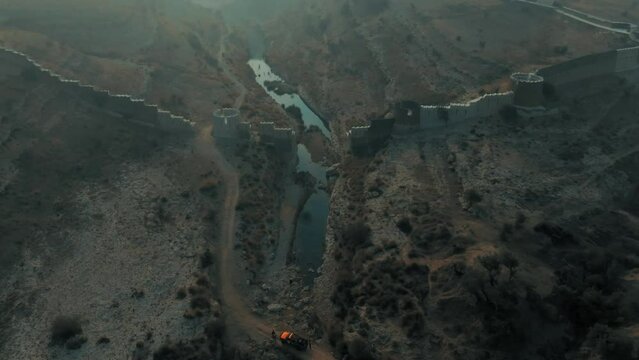 High drone flight at ranikot fort in sindh pakistan over river near historical ruins