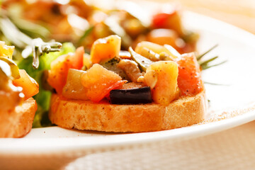 bruschetta with vegetables on white plate
