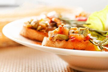 bruschetta with vegetables on white plate