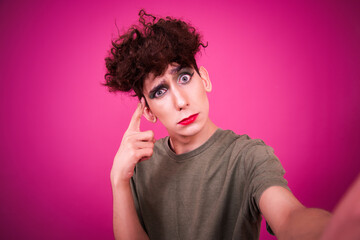 Funny guy dressed as a drag queen and online dating. Pink background.