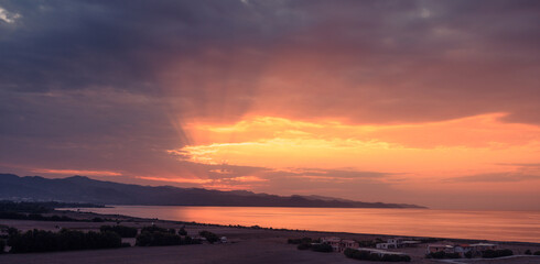 sunset over the Mediterranean sea, sun rays through the clouds