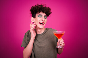 Funny guy dressed as a drag queen at a party. Pink background.