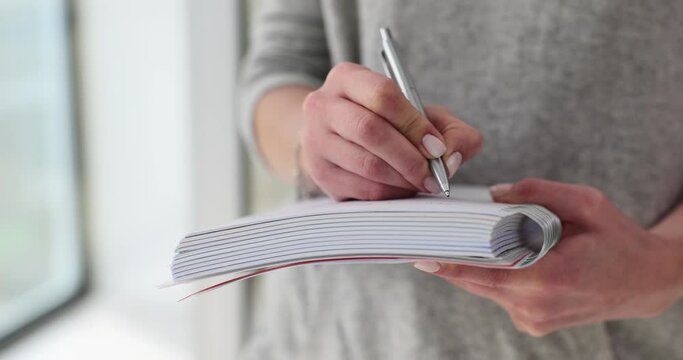 Woman writes in book with pen concept