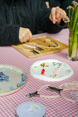 Set of multi-colored ceramic and plastic beads for needlework, child and mother are making jewelry...