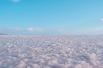 The vast floor of the salt lake in Turkey. The flat horizon line separates the blue sky from the...