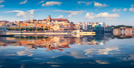 Colorful buildings of coastal town Otranto reflected in the calm waters of Adriatic sea. Sunny...