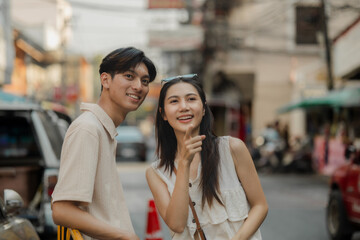 the young lovely couple is walking around traditional food market under the sun, love is showing from their face when they have conversation because they love each other, dating