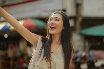 a beautiful Asian woman is walking around street food market in day time, lovely teenager is...
