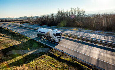 White Tanker or Tank Truck on a highway road at sunset