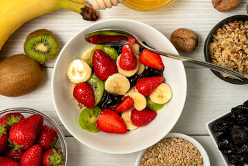 Healthy breakfast. Soaked organic raw barley, strawberries, walnuts, kiwi, banana, raisins, prunes...