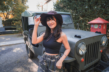 Obraz premium Beautiful woman soldier with a car on the camp