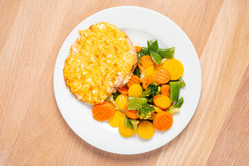 cutlet with roasted vegetables on white plate