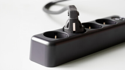 Powerful electrical extension cord, with four sockets, a power button and a connected electrical...