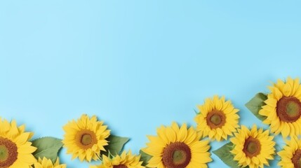 Obraz premium The image shows a blue background with sunflowers at the bottom. The sunflowers are yellow and have green leaves.