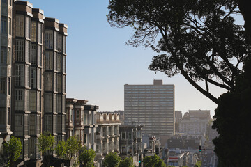 Picturesque Victorian house architecture with modern futuristic downtown San Francisco skyline silhouette panorama, cable car and bay view up and down hill