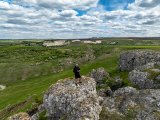 aerial view of a man standing on rock at varatic rock formation on the north of moldova