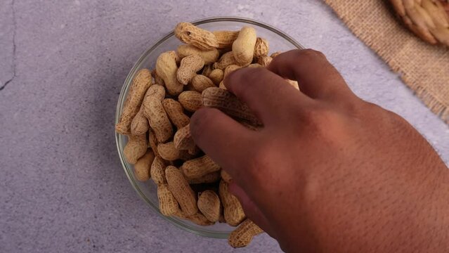 top view taking peanut in a glass bowl on stone or concrete table