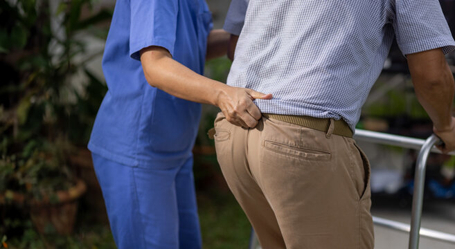 Caregiver holding gait belt for help support patient stand and walk in home