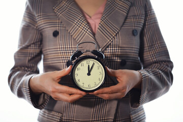 Portrait of beautiful young business woman holding in hands clock, white background, discipline and...