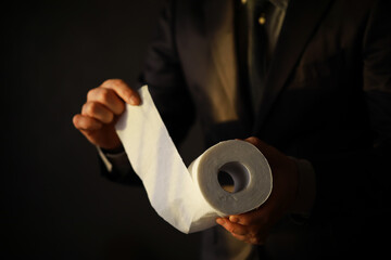 Rich Businessman paying in Toilet Paper, copy space. Toilet papers is the new currency