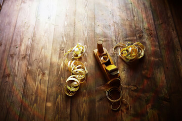 Hand planer with wooden sawdust. On a wooden background. High quality photo