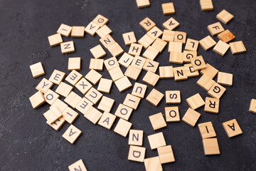 Top view of letters of the English alphabet scattered on a black background. The concept of the development of thinking, grammar