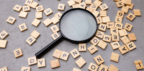 Magnifying glass with many wood letters of English alphabets, learning English concept