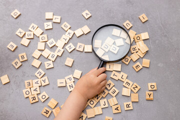 Square letter tiles with magnifying glass against blue background. Search for words and information...