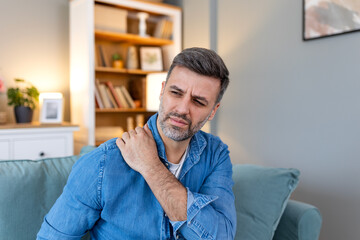 Young man with shoulder pain. male holding his painful shoulder. man hand holding his shoulder...