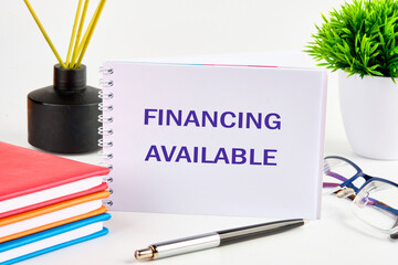 Business concept. Words Financing Available on a standing notebook on a white background