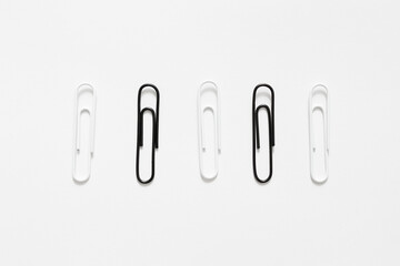 set of black and white paperclips over white background