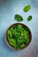 Fresh green spinach in a ceramic plate. Healthy food concept. Space for text.