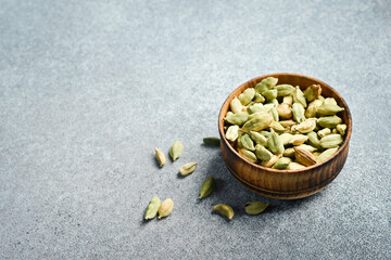 Aromatic spices. Dried cardamom seeds in a bowl on a concrete gray background.