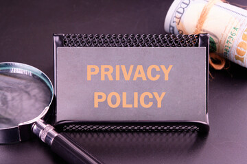 Finance and economics concept. Text PRIVACY POLICY on a gray business card in golden letters
