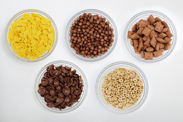 Top view of bowls with different cereals on white