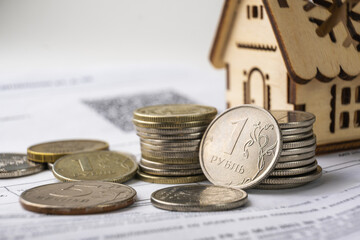 House model and coins on the background of financial documents. Real estate concept.