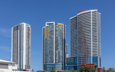 Three colorful high rise apartment buildings standing out against the skyline and presenting a...