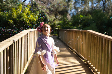 A pretty girl dancing flamenco in a typical gypsy dress with frills and fringes walks on a wooden...