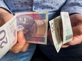 Man counts 10 20 zloty polish banknotes, saving concept