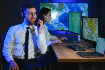 Center of dispatching maintenance. Portrait of cheerful woman and man working via headset...