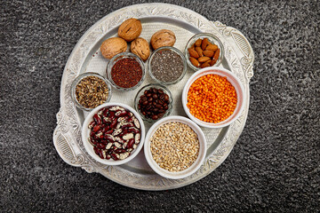 Beans and nuts selection in bowls: quinoa, chia, lentils, beans, almonds, walnuts, coffee beans on...