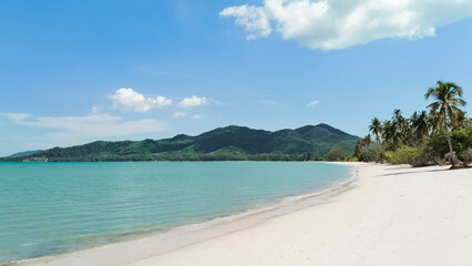 White sandy beach landscape with mountain view. Tropical beach travel. Summer trip.