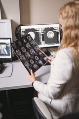 Female doctor examine an MRI image of the brain in an MRI room sitting at computer. Blurred image	