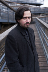 a serious man in a black coat on the street in Krasnoyarsk