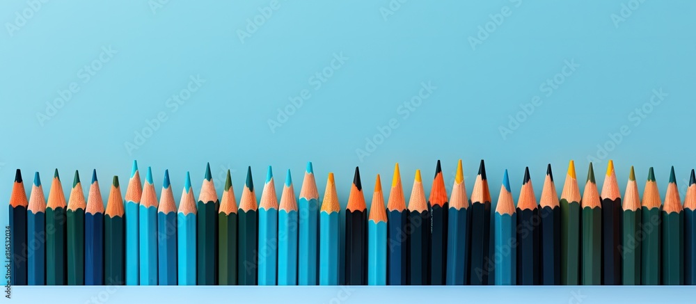 Aufkleber A vibrant arrangement of colored pencils rests on a notebook situated against a backdrop of serene blue The visually striking composition captured in a photograph features a copy space image ideal fo