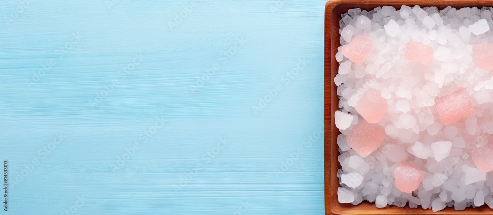 Poster top down flat lay image of a pink himalayan salt plate on a pastel blue background with ample space 