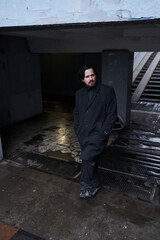 a serious man in a black coat on the street in Krasnoyarsk