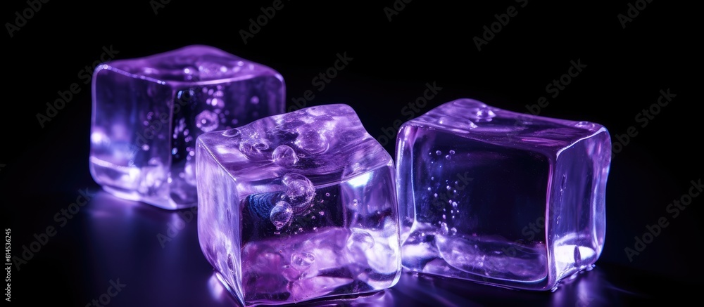 Poster Isolated on a black background there is a copy space image of transparent ice cubes illuminated by a soft purple light